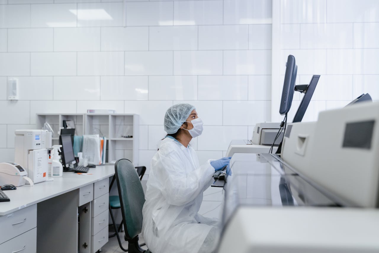 Pracownik laboratorium z certyfikowanym sprzętem Laborant w fartuchu trzymający probówkę obok dokumentu z hologramem certyfikatu