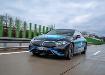 Nowoczesny samochód elektryczny z baterią i inżynierami w laboratorium warsztatowym