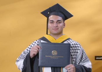 Zadowolony inżynier w garniturze trzyma dyplom MBA przed nowoczesnym biurowcem