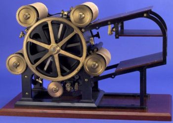 Naukowiec w białym kitlu trzyma patent obok mikroskopu i probówek laboratoryjnych