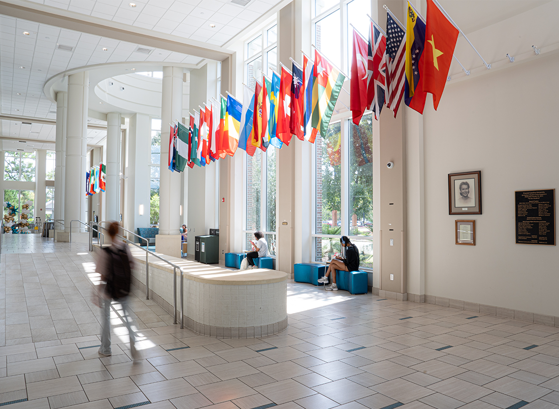 dwóch studentów analizujących dokumenty finansowe przy biurku z kalkulatorem