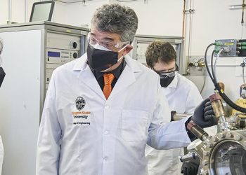 młody inżynier w koszuli siedzący naprzeciw rekrutera przy stole w nowoczesnym biurze