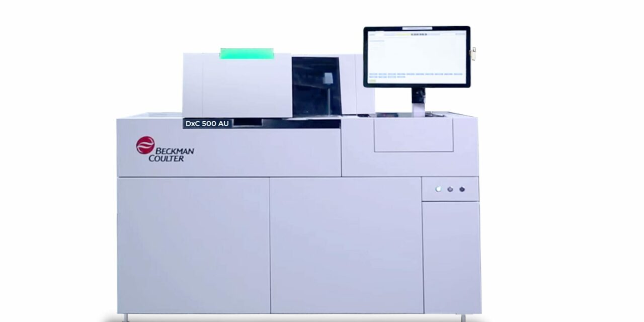 naukowiec w rękawicach ładujący granulat polimeru do analizatora