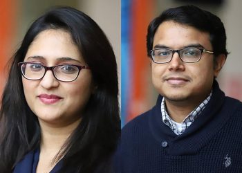 grupa studentów dyskutujących przy stole z laptopami i makietami projektów