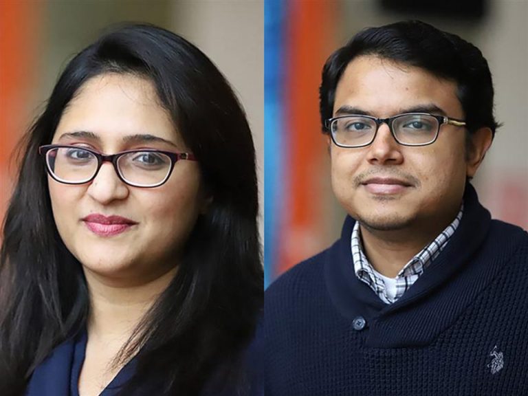 grupa studentów dyskutujących przy stole z laptopami i makietami projektów