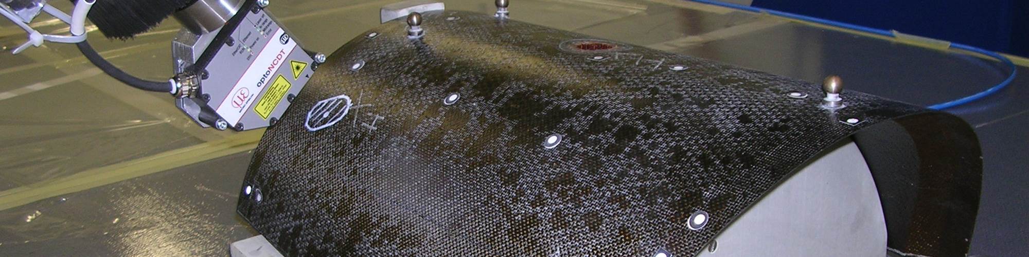 robot przemysłowy układający taśmy kompozytowe na kadłubie samolotu